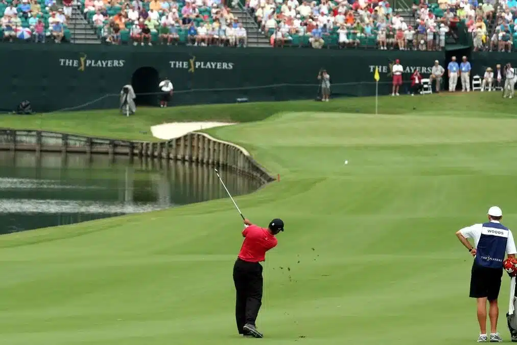 Tiger Woods #18 TPC - a man playing golf on a green near a pond